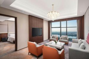 a living room with a television and a room with a bed at Le Meridien Shaoxing Yuecheng in Shaoxing