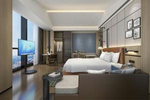 ein Hotelzimmer mit einem Bett und einem Flachbildfernseher in der Unterkunft Four Points by Sheraton Kunming Guandu in Kunming