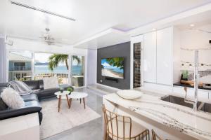 a kitchen and living room with a couch and a tv at Grape Tree Condo #10 in George Town