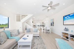 a living room with a couch and a tv at Cassava Pointe 4D at Sea Haven in Omega Gardens +42 photos