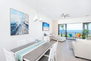 a dining room with a table and chairs and the ocean at Cassava Pointe 4D at Sea Haven in Omega Gardens