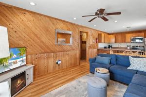 a living room with a blue couch and a tv at 7144 - Dolphin Lookout ( formerly Sabah Vacations) in Wanchese +50 photos