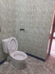 a bathroom with a toilet and a tiled wall at Hostel Assafar in Ouarzazate