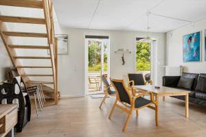 a living room with a staircase and a table and chairs at 0497-Romo-Vestergade-101-App-39 in Sønderby