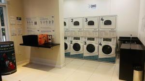 a laundry room with four washing machines on the wall at Studio Guarulhos 208 in Guarulhos