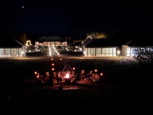 a group of chairs and a tent at night at dreaming desert Luxury Camp in Adrouine