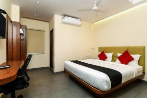 a hotel room with a bed and a desk and a desk at FabHotel Siddarth Grand in Vijayawada +35 photos