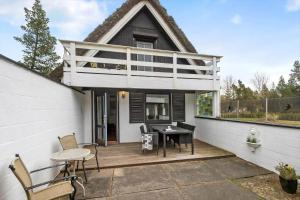a house with a deck with a table and chairs at 0162-Romo-Rabjergvej-97 in Kongsmark
