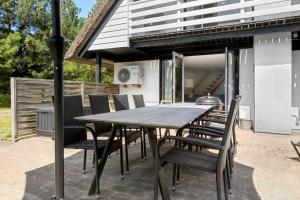 a wooden table and chairs on a patio at 0339-Romo-A-Hveyselsvej-32 in Rømø Kirkeby