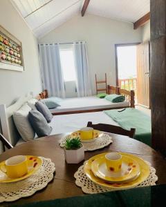 a room with a table with plates and cups on it at pe na areia in Arraial do Cabo