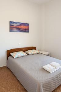 a bedroom with a bed with two towels on it at Your refuge overlooking port 6A in Mytilene