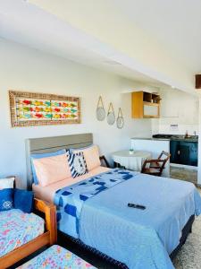 a bedroom with a bed and a table and a kitchen at pe na areia in Arraial do Cabo +34 photos