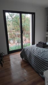 a bedroom with a bed and a large sliding glass door at Maison de campagne in Périssac +4 photos