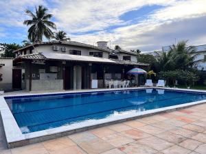 ein Swimmingpool vor einem Haus in der Unterkunft Condomínio Ouro – Piscina e Praia a Poucos Passos in Porto Seguro