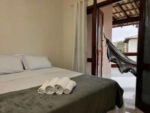 ein Schlafzimmer mit einem Bett mit Handtüchern darauf in der Unterkunft Condomínio Ouro – Piscina e Praia a Poucos Passos in Porto Seguro