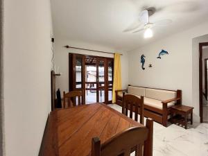 ein Esszimmer mit einem Holztisch und Stühlen in der Unterkunft Condomínio Ouro – Piscina e Praia a Poucos Passos in Porto Seguro