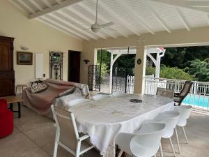 een eetkamer met een witte tafel en stoelen bij Kaz Raphitou in Bouillante