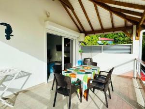a patio with a table and chairs on a porch at Le Marjulem - Logement cosy et bagagerie incluse in Terre-de-Haut