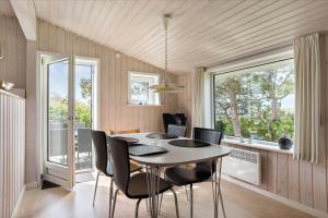 Un comedor con mesa y sillas y ventanas. en 0056-Romo-Lakolk-50, en Lakolk 14 fotos más