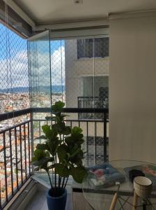 a room with a glass table and a large window at 1505 studio guarulhos in Guarulhos