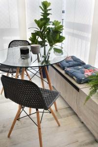 a glass table and chairs in a room with a couch at 1505 studio guarulhos in Guarulhos +8 photos