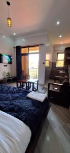 a bedroom with a large bed and a living room at CALM STAYs in Kampala