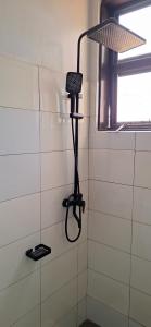 a room with a shower with a microphone in the corner at CALM STAYs in Kampala +10 photos