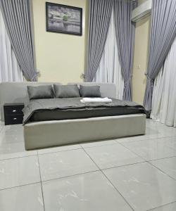 a large bed in a room with curtains at Wood Lake Apartment in Dushekoro