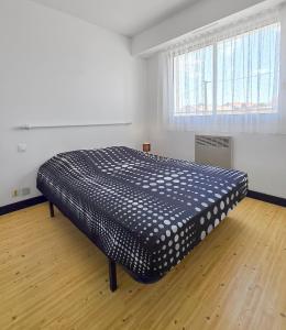 ein großes Bett in einem Zimmer mit Holzboden in der Unterkunft T2 Cosy à 800mètres de la mer in Saint-Jean-de-Monts