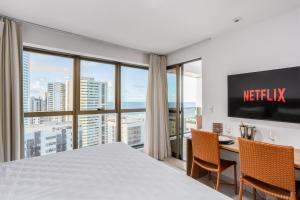 Una habitación de hotel con una cama y un escritorio con sillas. en BEIRA MAR- FLAT EXECUTIVE, en Recife
