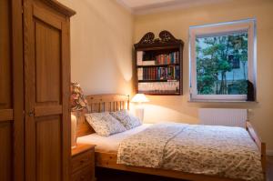 a bedroom with a bed with a window and a book shelf at Apartament Mundus in Sopot
