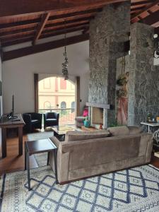 a living room with a couch and a stone wall at Apartamento ao lado do Shopping Lamérica in Bento Gonçalves