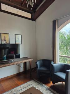 a living room with chairs and a table and a window at Apartamento ao lado do Shopping Lamérica in Bento Gonçalves