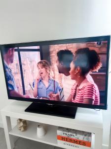 a flat screen tv sitting on top of a white table at Studio in Lormont with Free Parking in Lormont