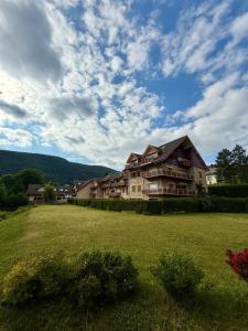 a large house on a grassy field with a sky at T3 façon Chalet, terrasse et garage privé, Villard-De-Lans in Villard-de-Lans
