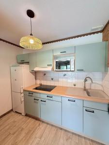a kitchen with white cabinets and a sink at T3 façon Chalet, terrasse et garage privé, Villard-De-Lans in Villard-de-Lans