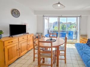 ein Wohnzimmer mit Tisch und Fernseher in der Unterkunft T2 Cosy à 800mètres de la mer in Saint-Jean-de-Monts