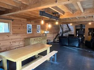 a dining room with wooden walls and a wooden table at Superbe grange sur une colline in Asté