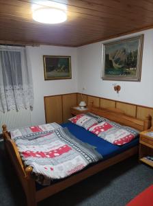 a bedroom with a bed with a blue comforter at Penzion furovi in Ostrov