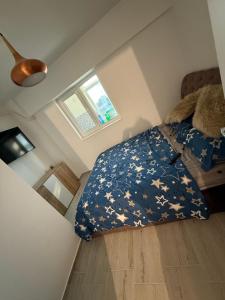 a bedroom with a bed with a blue blanket with stars at Apartament Bella in Craiova