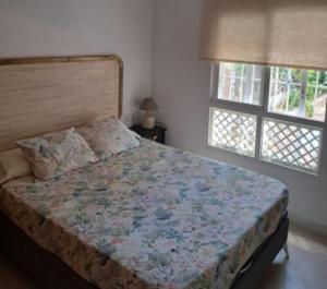 a bed in a bedroom with two windows at Doña Violeta - La Barrosa in Novo Sancti Petri
