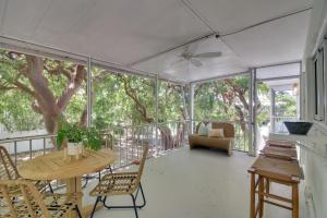 TavernierにあるSteps to Gulf Sleek Top-Floor Apt in Tavernier!のテーブルと椅子が置かれた網戸付きのポーチ