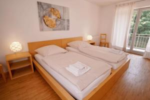 a bedroom with a large bed with white sheets at Apartments Im Sportpark in Weil am Rhein