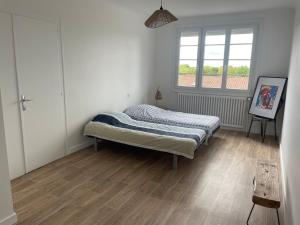 a bedroom with a bed and a window at Farmhouse in Montaigu-Vendée