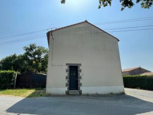 a small white building with a door on a street at Farmhouse in Montaigu-Vendée