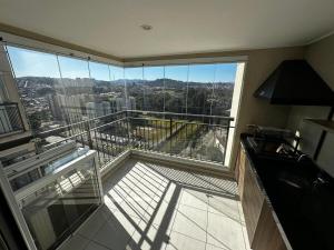 a large room with a balcony with a view of a city at Studio Cidade Maia Guarulhos 17! in Água Boa