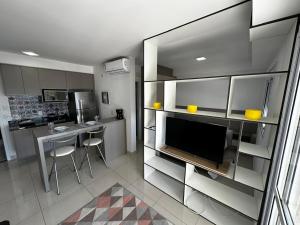 a kitchen with a television and a table with chairs at Studio Cidade Maia Guarulhos 17! in Água Boa +5 photos