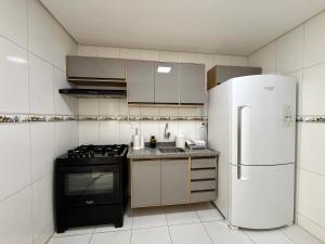 a kitchen with a stove and a refrigerator at Edificio Artur Regis in Petrolina