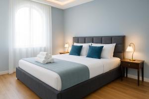 a bedroom with a large bed with blue pillows at Boutique Hotel Aviator in Belgrade