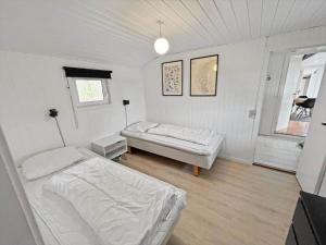 a white room with two beds and a window at 0115-Romo-Lakolk-225 in Lakolk